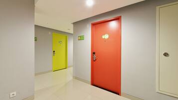 A corridor with a red door and a yellow door, both with room numbers visible.