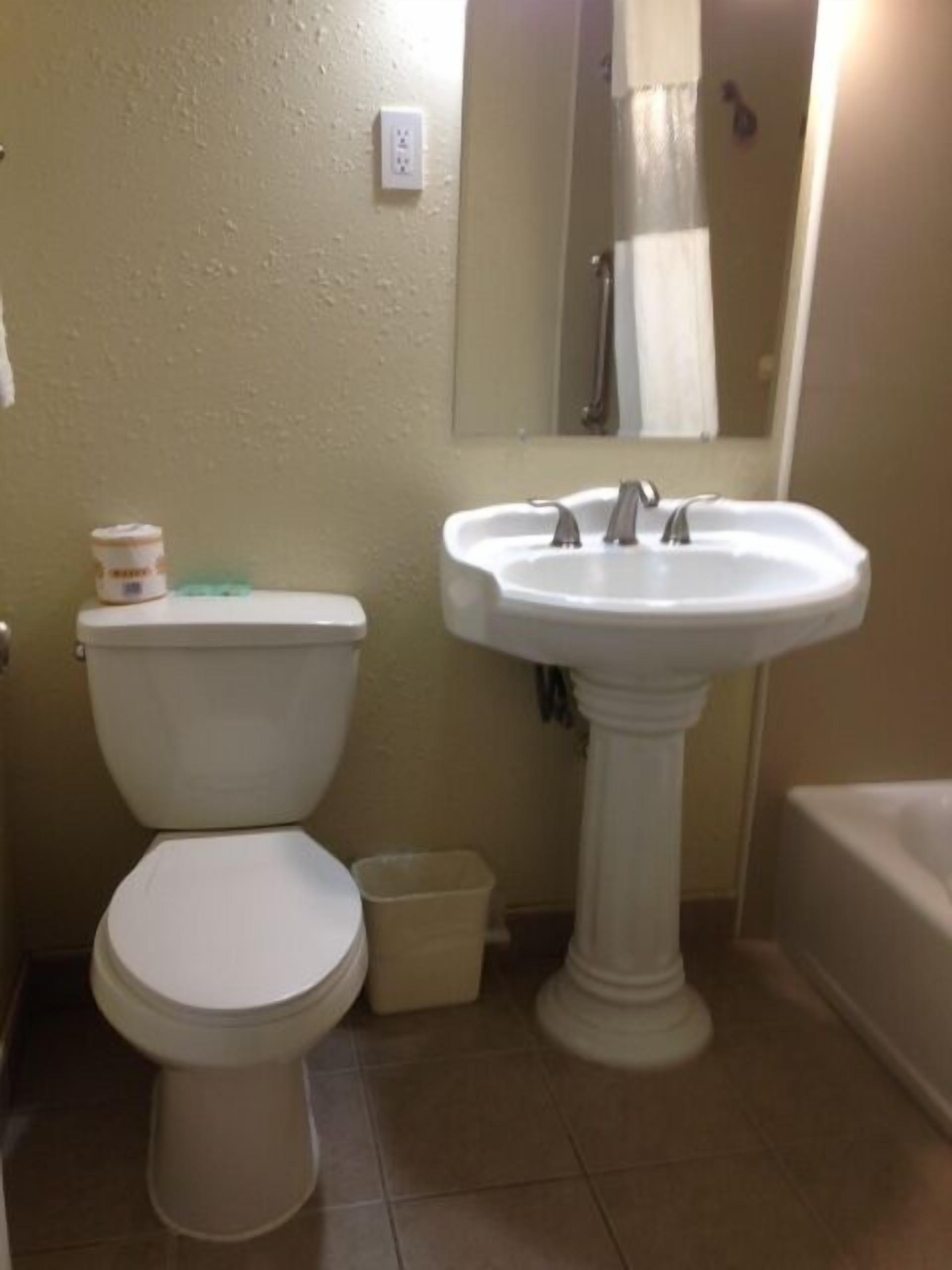 A bathroom with a toilet, sink, and bathtub.