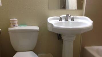 A bathroom with a toilet, sink, and bathtub.