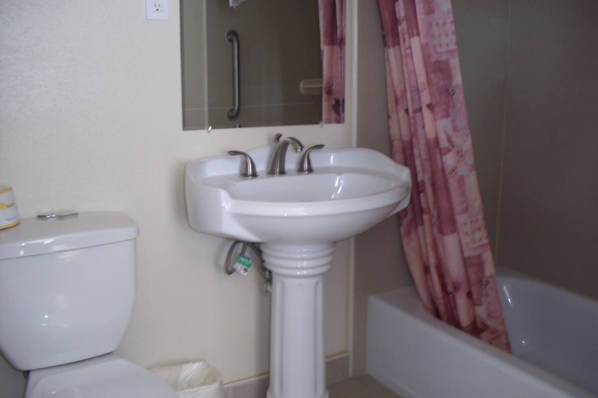 A bathroom with a pedestal sink, toilet, and bathtub.