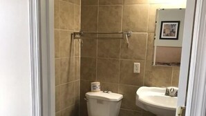 Un baño con inodoro, lavamanos y perchero para toallas.