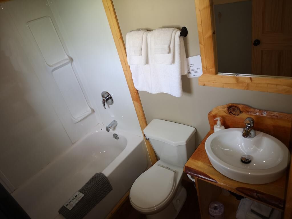 A bathroom with a bathtub, toilet, and sink.