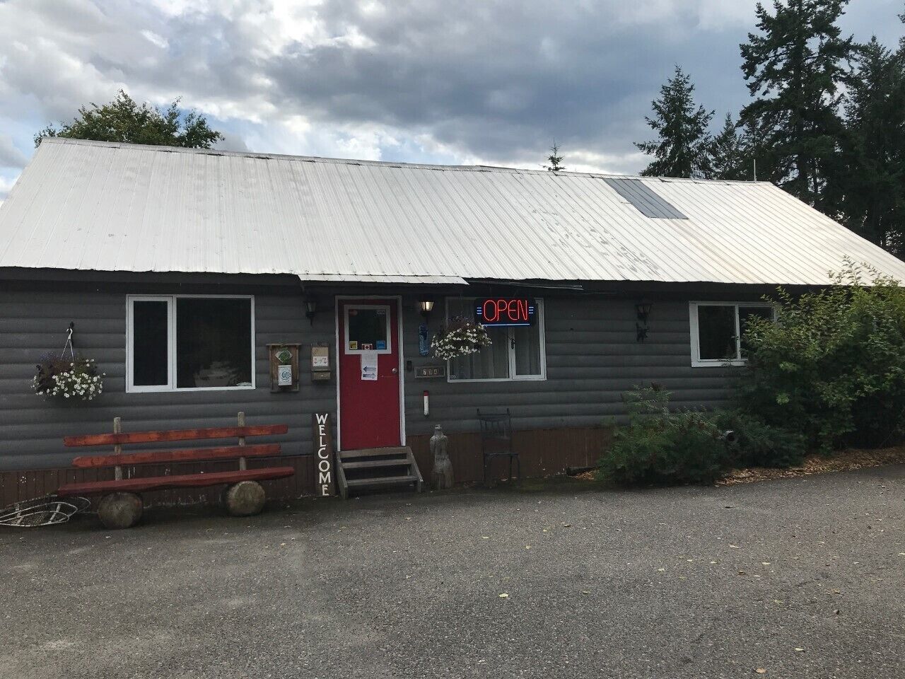 A small, single-story building with a red door and a 'OPEN' sign.