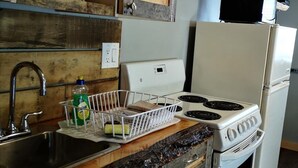 Una cocina con encimera de madera, cafetera, estufa y refrigerador.
