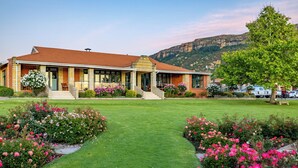 A two-story building with a red-tiled roof, a covered porch, and a well-maintained lawn with flower beds. - Botleng Guest House (Maseru)
