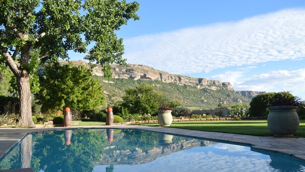 A swimming pool with a clear view of a mountainous landscape in the background. - Botleng Guest House (Maseru)