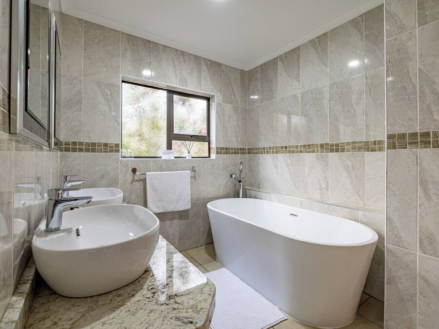 A bathroom with a freestanding bathtub, a large sink, and a window.