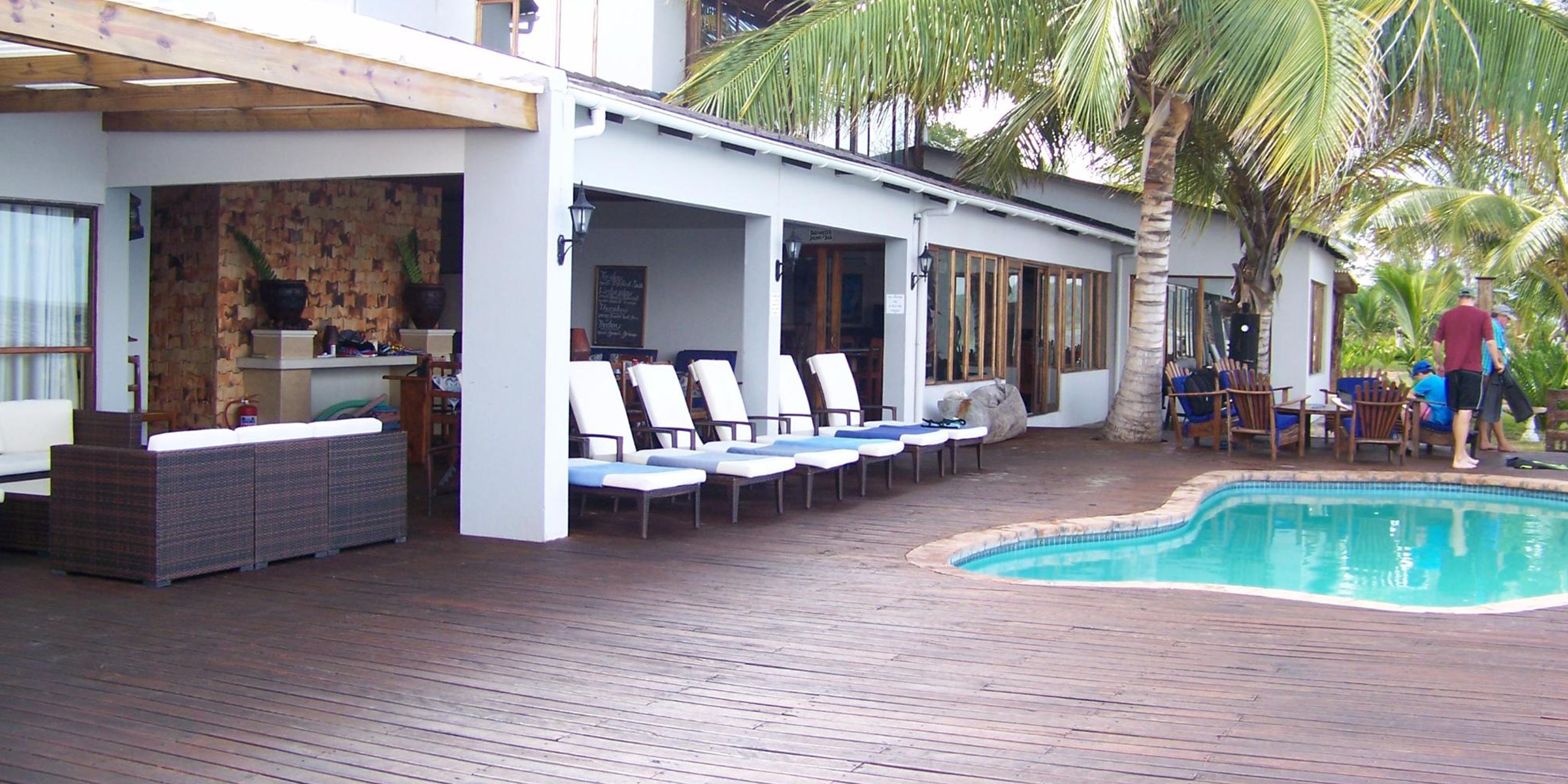 A poolside area with lounge chairs, a wooden deck, and a small pool.