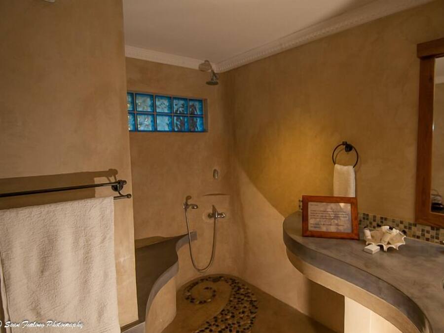 Ein Badezimmer mit Dusche, Waschbecken und Spiegel.