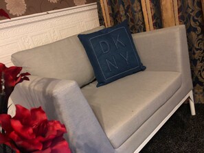 A light grey sofa with a blue cushion that has "DANV" embroidered on it. - Ashfield Hotel (Huddersfield)