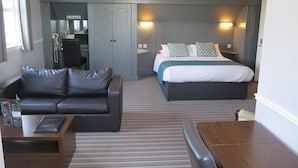 Une chambre d’hôtel avec un lit, un canapé, un bureau et un miroir.
