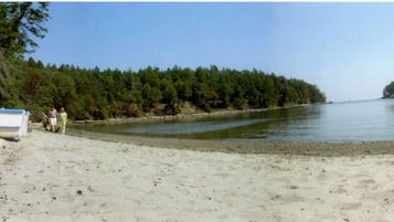 Enjoy a serene beach day with a tranquil body of water and scenic views.