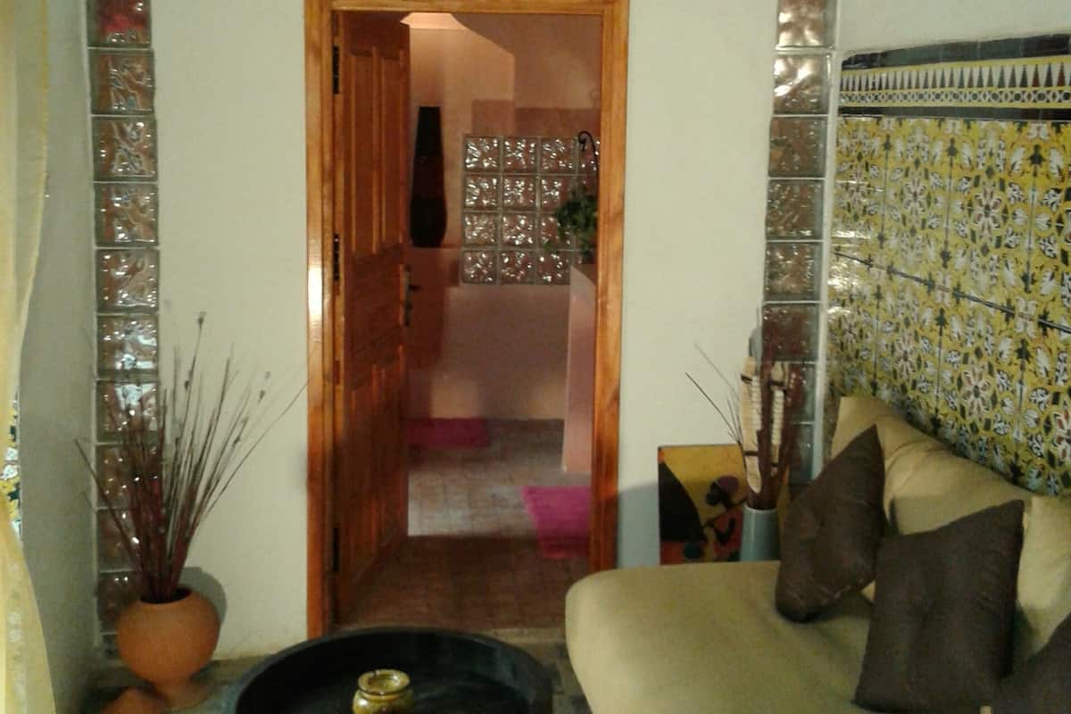 A living room with a sofa, a small table, and a decorative wall.