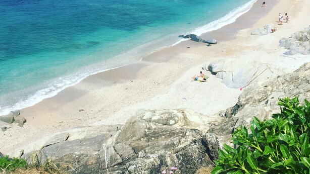 A beach with clear turquoise waters, a sandy shore, and rocky cliffs. - Smarties Guest House (Newquay)