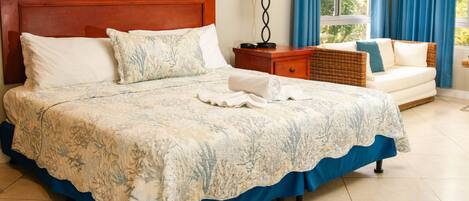 A neatly made bed with a blue and white floral bedspread, a wooden headboard, and a white pillow.