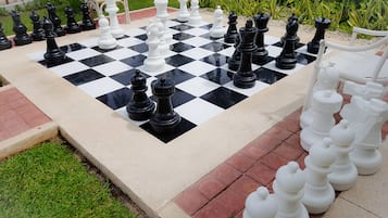 Play a game of chess in a scenic outdoor setting.