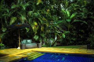 Una piscina al aire libre, sombrillas, sillones reclinables de piscina