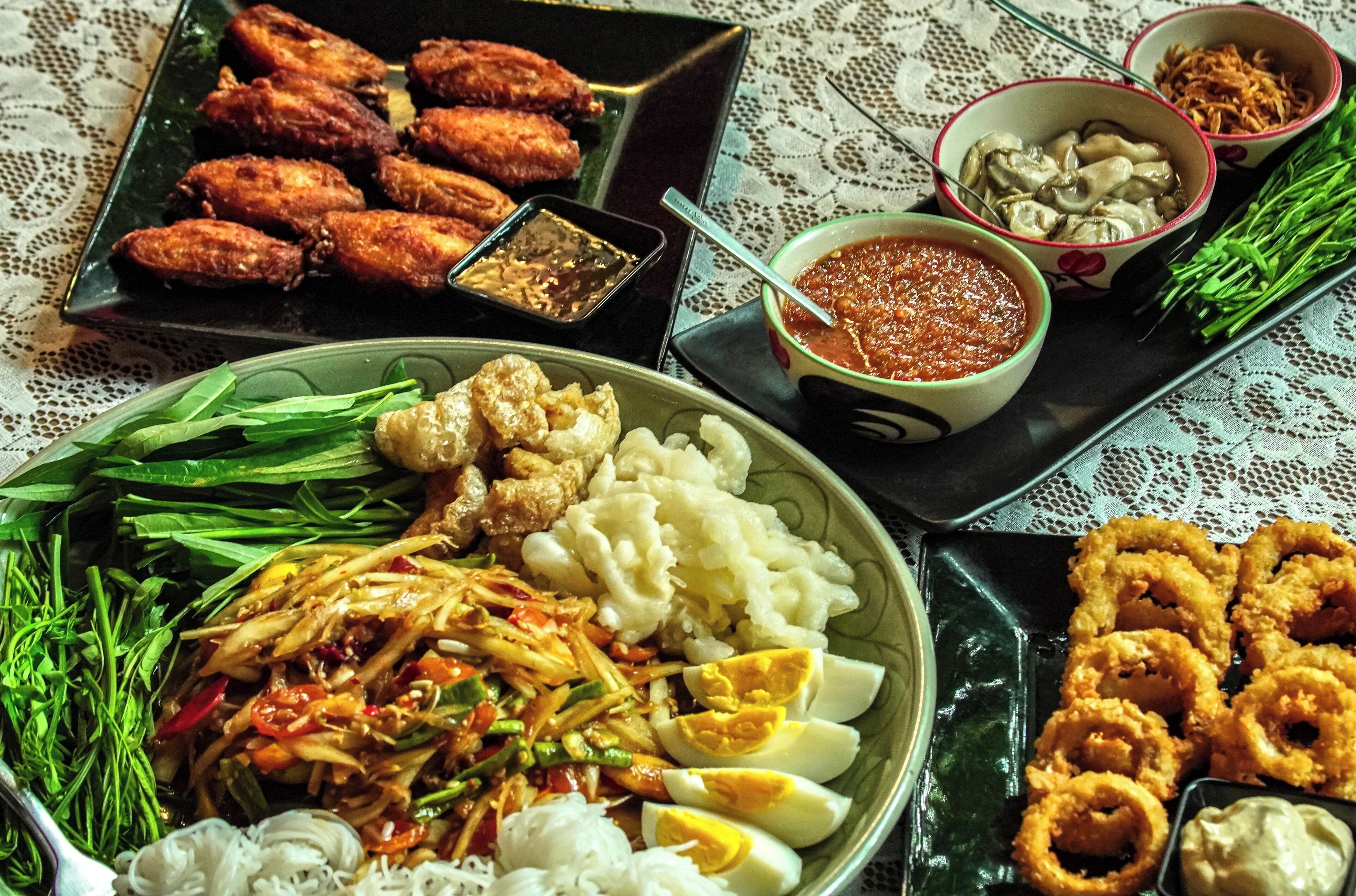 A variety of dishes including fried chicken, rice, and vegetables on a table.