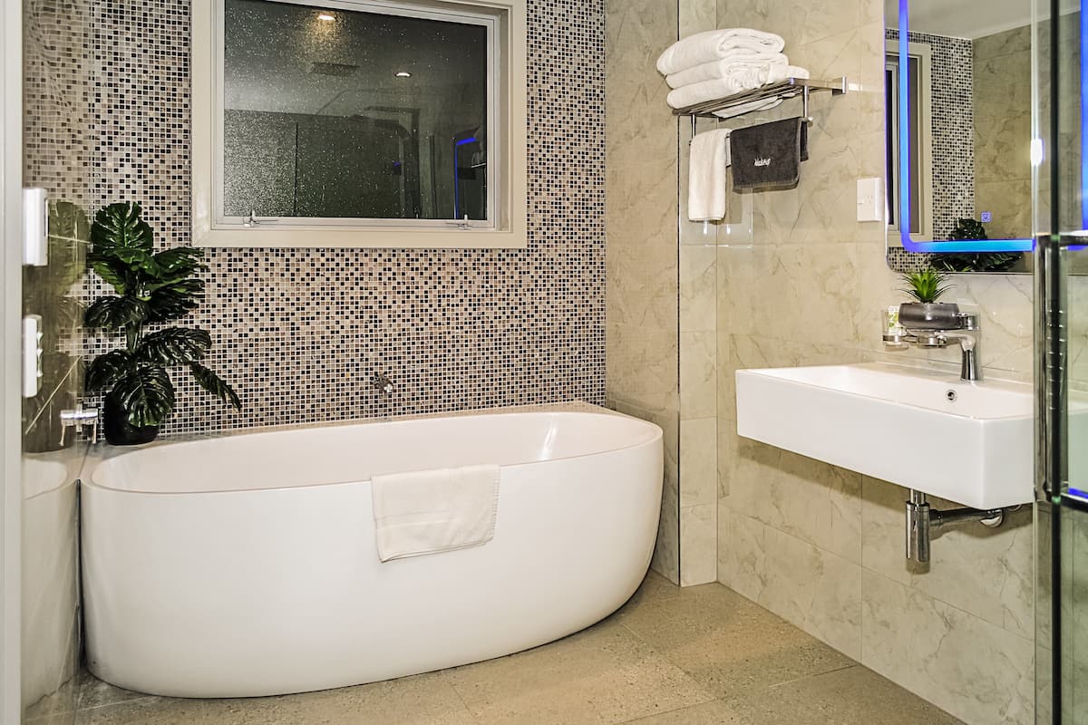 A modern bathroom with a freestanding bathtub, a sink, and a mirror.