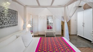 Une chambre à coucher comprenant un lit, une table de chevet, une commode, une fenêtre et une armoire.