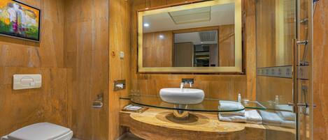 A modern bathroom with a marble vanity, a glass shower enclosure, and a large mirror.