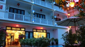 A hotel with multiple balconies, potted plants, and outdoor seating. - Phuc Thao Villa (Da Nang)