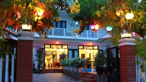 A building with a balcony, potted plants, and a gated entrance. - Phuc Thao Villa (Da Nang)