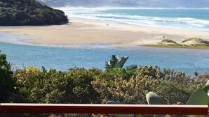 A beach with a view of the ocean and distant hills. - Buccaneers Backpackers (Great Kei)