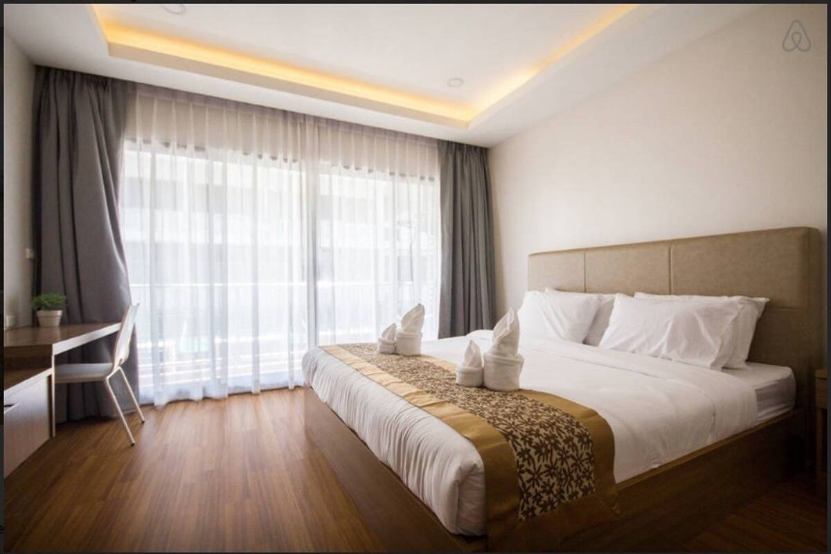 A hotel room with a bed, a desk, and a chair.