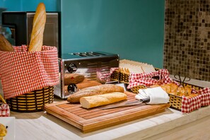Una encimera de cocina con panes varios y una tostadora.