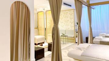 Relax in a serene space with a large bed, sofa, and chair, plus a balcony offering city views.