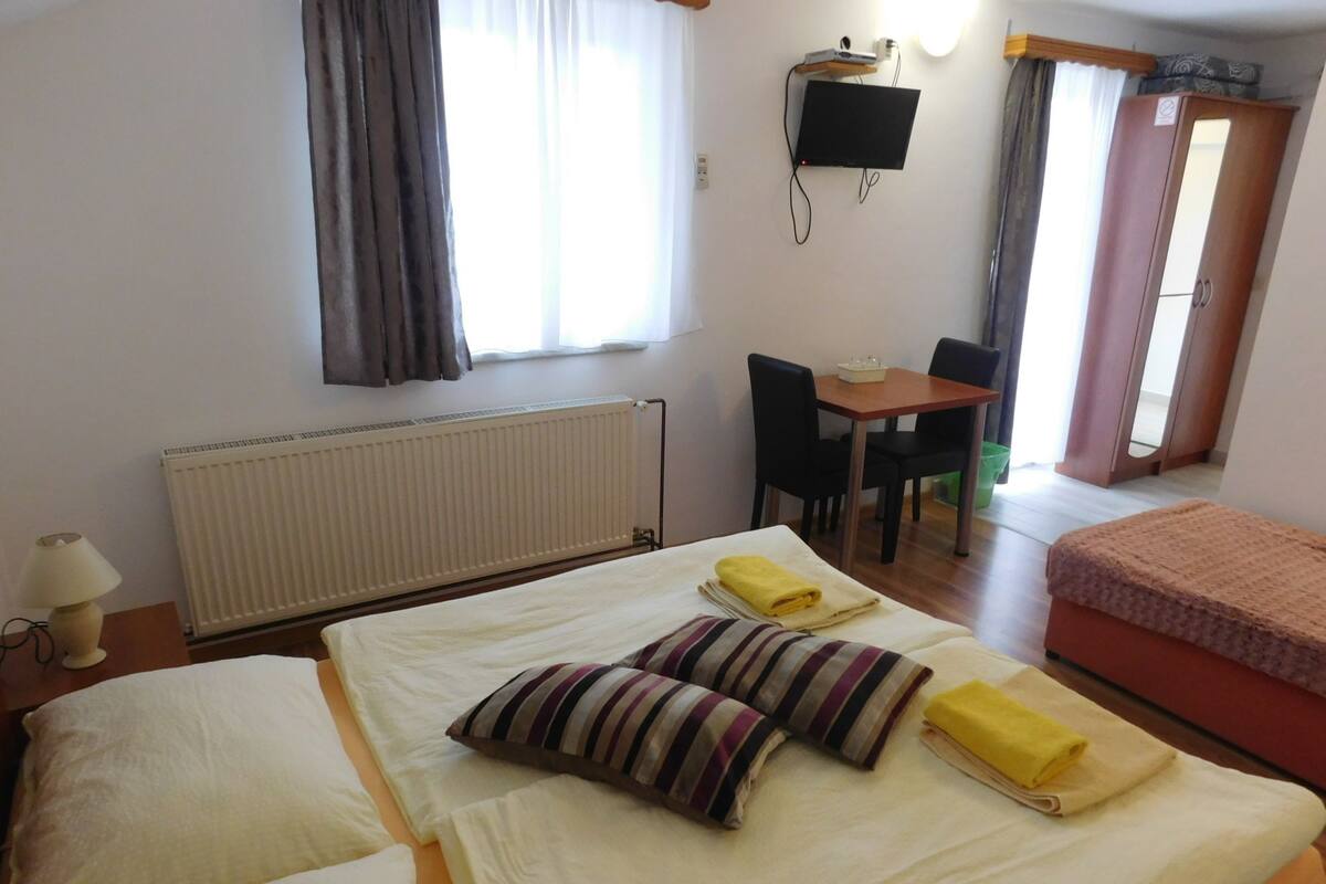 A hotel room with two beds, a desk, and a chair.
