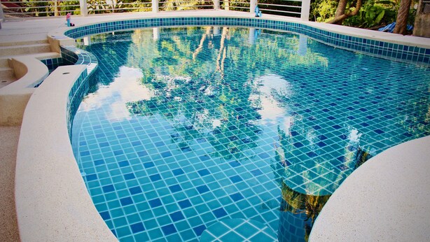 A swimming pool with a tiled edge and a curved design. - Budchui Village 2 (Koh Tao)