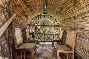 Un espacio de estar cerrado con paredes tejidas y una estructura de madera central.