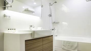 A modern bathroom with a vanity, mirror, shower, and bathtub.