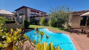 A pool area with a building labeled 'KATHU INN by COUNTRY HOTELS'. - Kathu Inn by Country Hotels (Kathu)