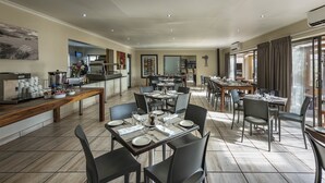 A spacious dining area with multiple tables and chairs, a coffee station, and a view of the outdoors. - Kathu Inn by Country Hotels (Kathu)