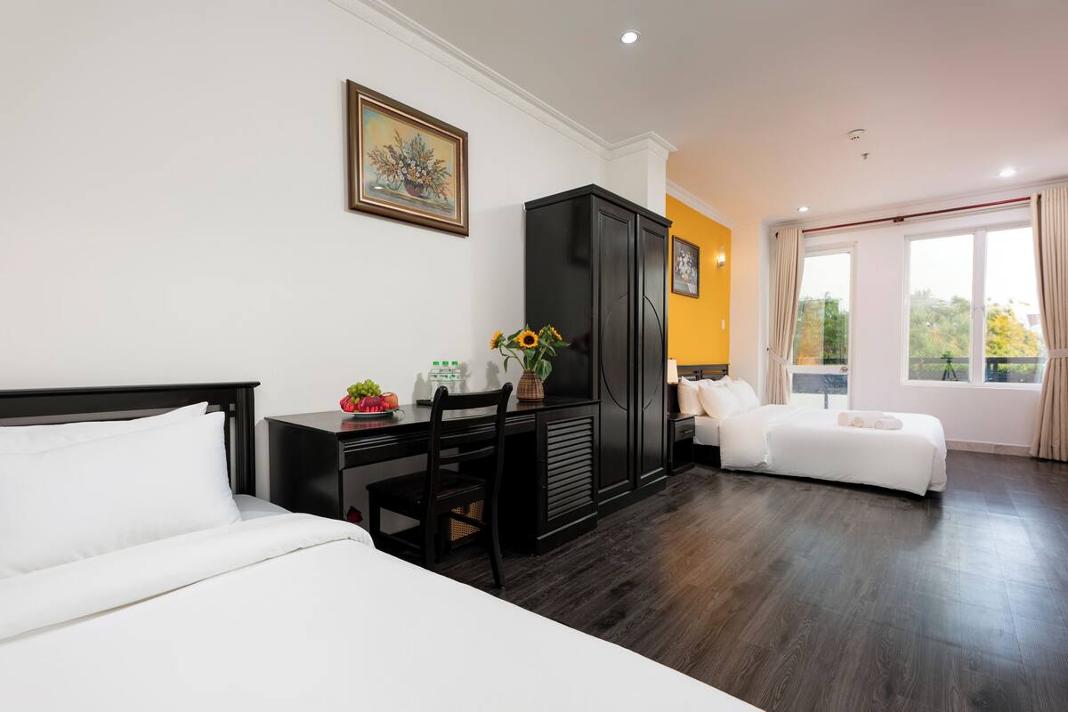 A hotel room with a bed, a desk, a wardrobe, and a sofa.