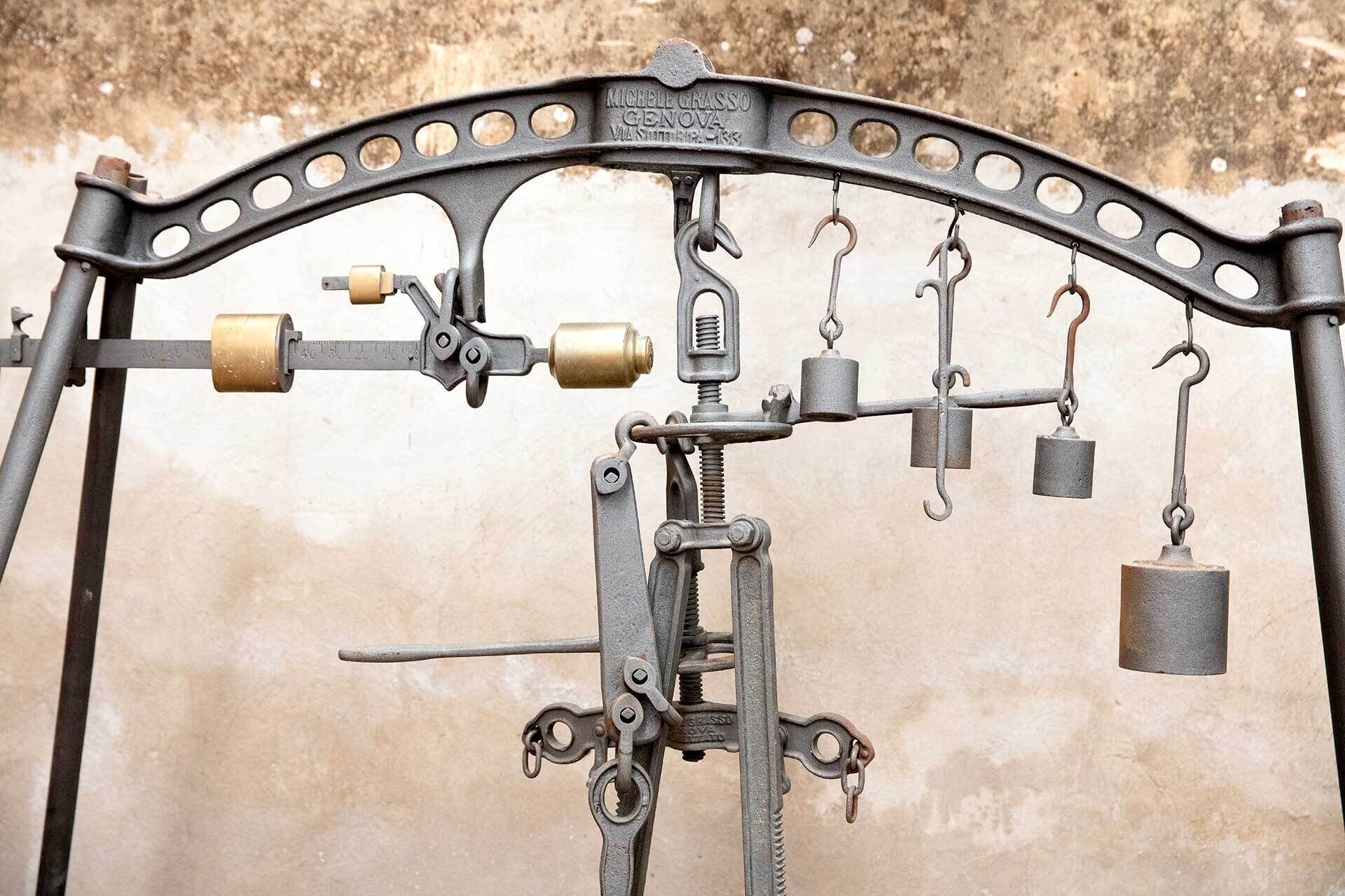 A vintage mechanical scale with weights and a dial gauge, likely used for measuring ingredients or materials.
