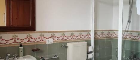 Un baño con lavamanos, bidé, inodoro y ducha.