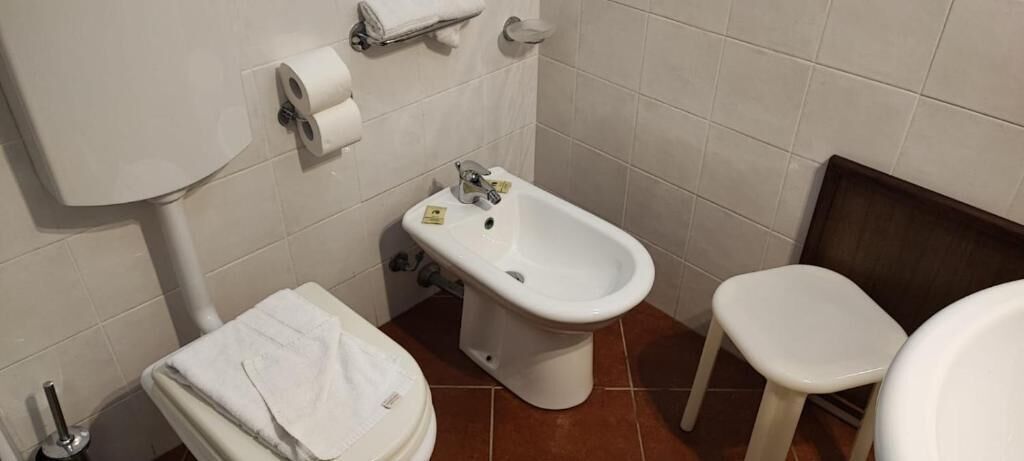 A bathroom with a toilet, bidet, and sink.