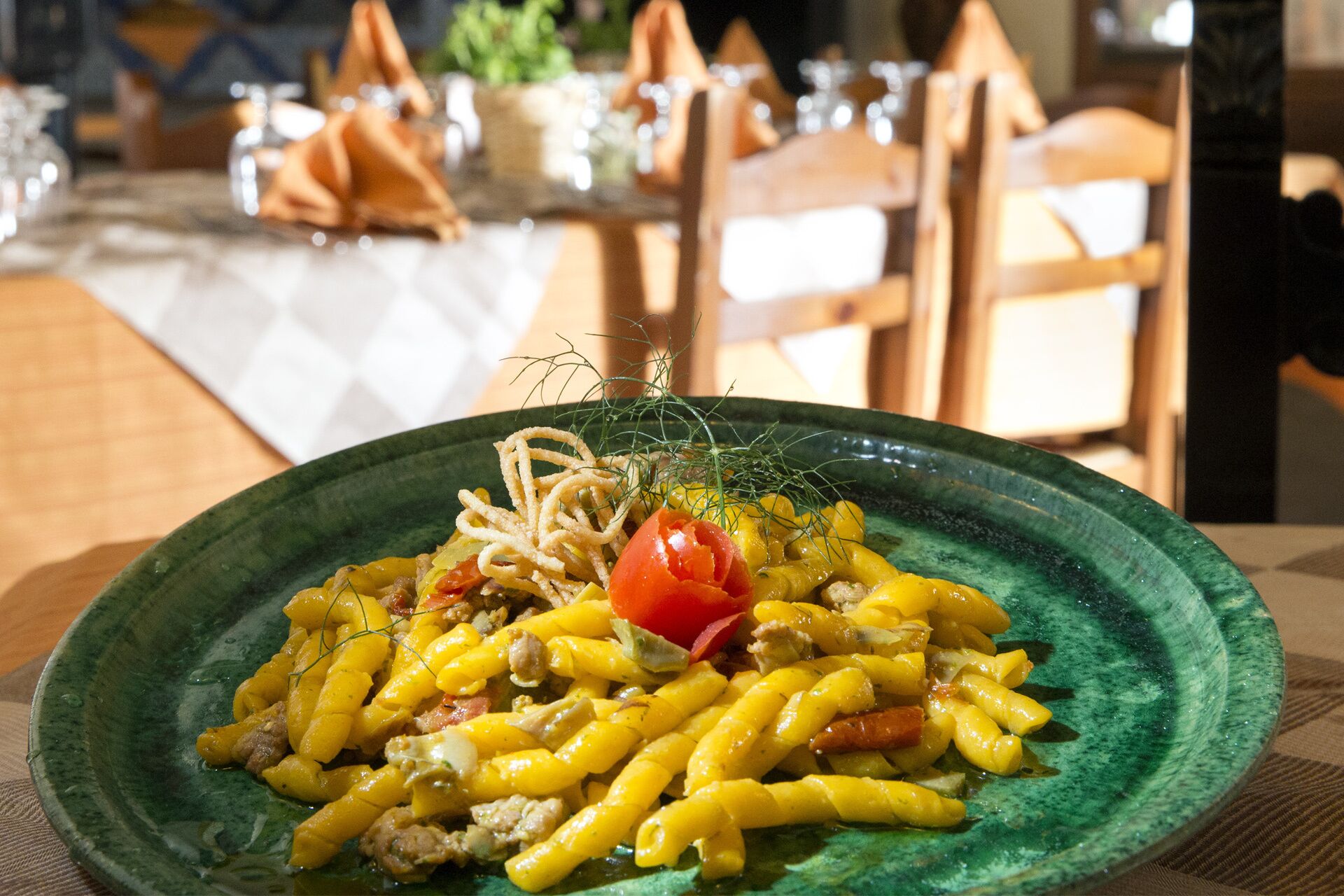 Een bord pasta met groenten en een garnering van kerstomaatjes.