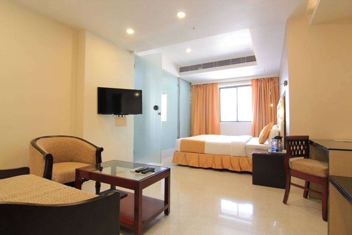 A hotel room with a bed, a television, a desk, and a chair.