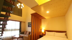 A hotel room with a wooden ceiling, a bed, a sofa, a desk, and a chandelier. - Hualien Lohas Hotel (Hualien City)