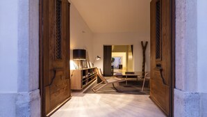 A hallway with a wooden door frame, a bookshelf, and a seating area with a chair and a table.