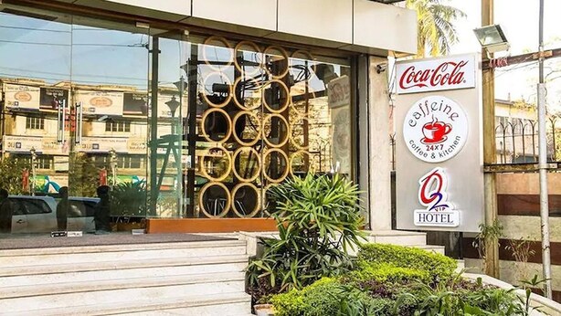 A hotel entrance with a Coca-Cola sign, a 24x7 coffee & kitchen sign, and a VIP hotel logo. - Hotel O2 VIP (Barasat)