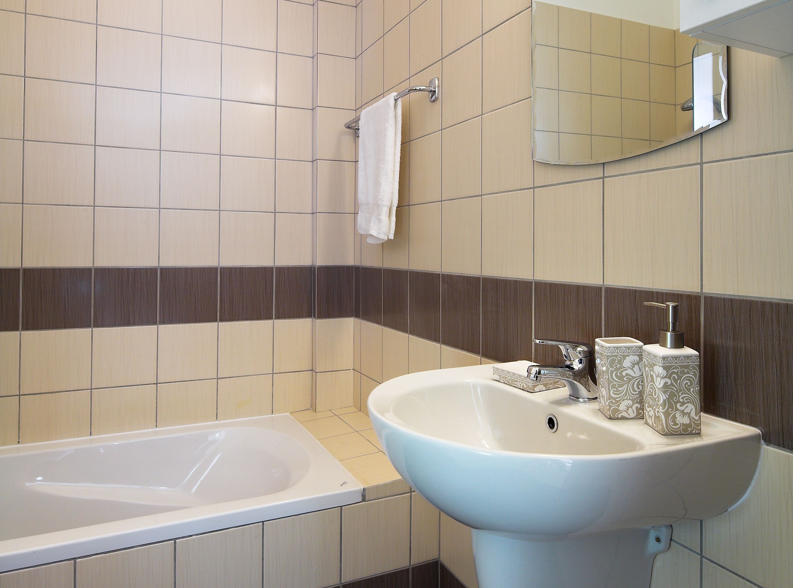 A bathroom with a bathtub, a sink, and a mirror.