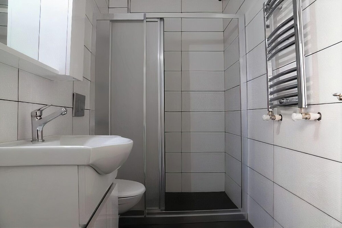 A modern bathroom with a shower, toilet, and sink.