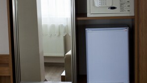 Un armario de madera con un microondas y un refrigerador pequeño.