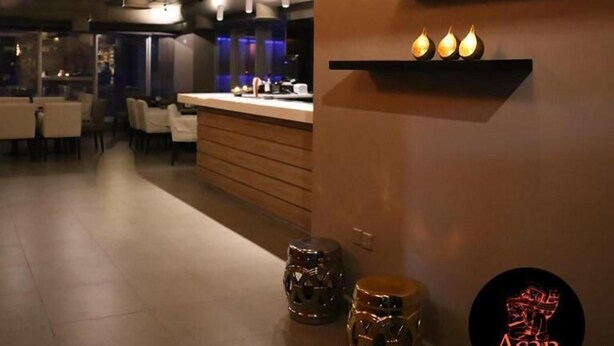 Een modern interieur met een receptiebalie, een zithoek en decoratieve wandelementen.